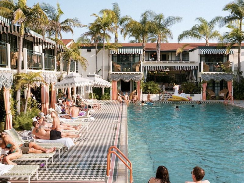 The Lafayette pool: black-and-white checkerboard tile, striped awnings, cabanas and palms.